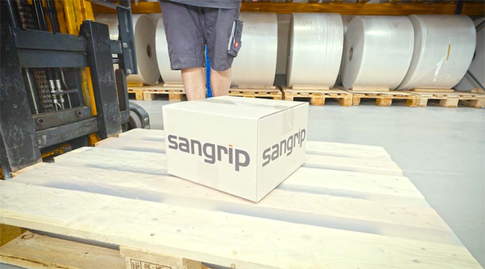 Cardboard box with sangrip logo on wooden pallet in warehouse