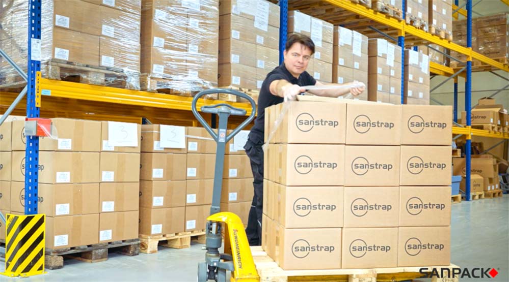 Employee secures boxes on pallets with sanstrap® stretch film in the warehouse