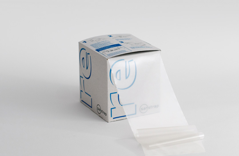Sanstrap® re Spenderbox mit transparentem Dehnband aus Recyclingmaterial zur Palettensicherung.