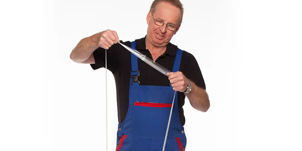 Mitarbeiter hält sanstrap® Dehnband als Musterprobe in der Hand